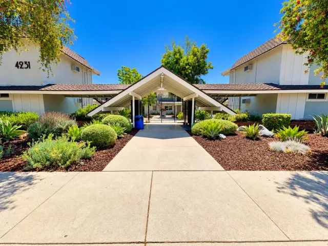 Covered entryway between two buildings with a landscaped walkway