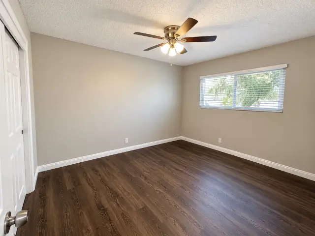Bedroom with a ceiling fan and wood-style flooring